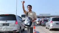 Petugas Lintas Marga Sedaya (LMS) saat mengatur arus kendaraan  di pintu keluar Pejagan, Jawa Tengah, Sabtu (2/7). Petugas melakukan sistem 'jemput bola' pembayaran tiket tol untuk mengurai kemacetan saat arus mudik. (Liputan6.com/Angga Yuniar)