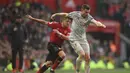 Duel Alexis Sanchez dan James Milner pada laga lanjutan Premier League yang berlangsung di stadion Old Trafford, Manchester, Minggu (24/2). Man United bermain imbang 0-0 kontra Liverpool. (AFP/Oli Scarff)