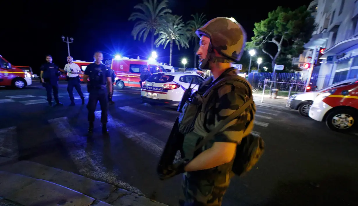 Tentara membuat pagar betis di lokasi serangan teror truk di Nice, Prancis, Kamis (14/7). Setidaknya 60 orang tewas dan ratusan lainnya terluka saat sebuah truk menabrak kerumunan ramai yang merayakan libur nasional Bastille Day. (REUTERS/Eric Gaillard)