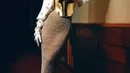 Hooded dress yang dikenakan Luna Maya terdiri dari corset emas, dipasangkan dengan rok jaring-jaring bernuansa emas yang serasi, dan pasangan hooded putih dengan payet bunga yang cantik yang menyambung menjadi gloves menutupi lengan. [Foto: Instagram/lunamaya]