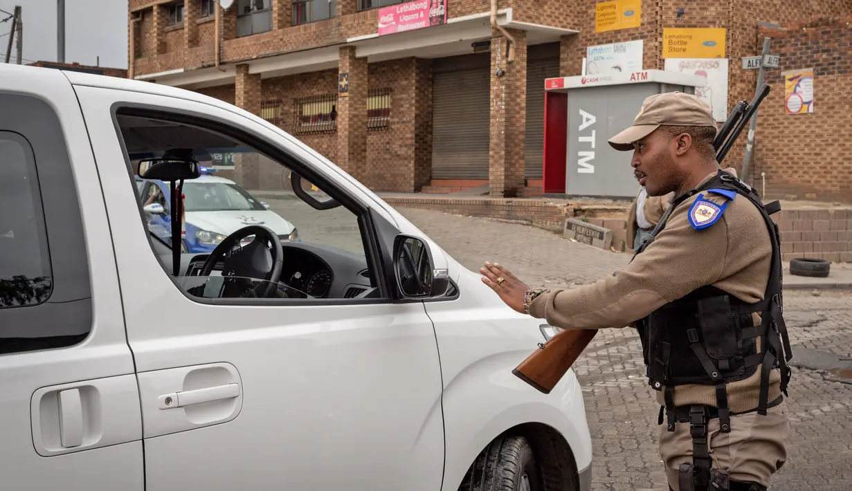 Polisi memeriksa sebuah mobil di jalanan Johannesburg, Afrika Selatan, Senin (30/3/2020). Presiden Afrika Selatan Cyril Ramaphosa menetapkan karantina wilayah atau lockdown nasional selama 21 hari untuk mencegah penularan virus corona COVID-19. (Xinhua/Yeshiel Panchia)