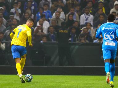 Pemain Al-Nassr, Cristiano Ronaldo, berusaha melewati pemain Al-Hilal pada laga persahabatan di Kingdom Arena, Riyadh, Jumat (9/2/2024). (AFP/Fayez Nureldine)