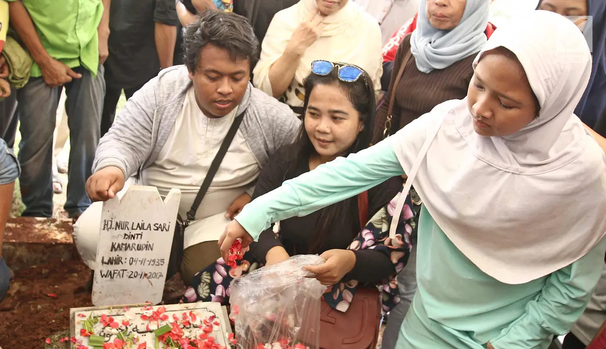 Kerabat dan keluarga menaburkan bunga di pemakaman Laila Sari  Tempat Pemakaman Umum (TPU) Karet Bivak, Jakarta, Selasa (21/11). Laila Sari meninggal dunia saat pulang syuting, di usai 82 tahun. (Liputan6.com/Herman Zakharia)