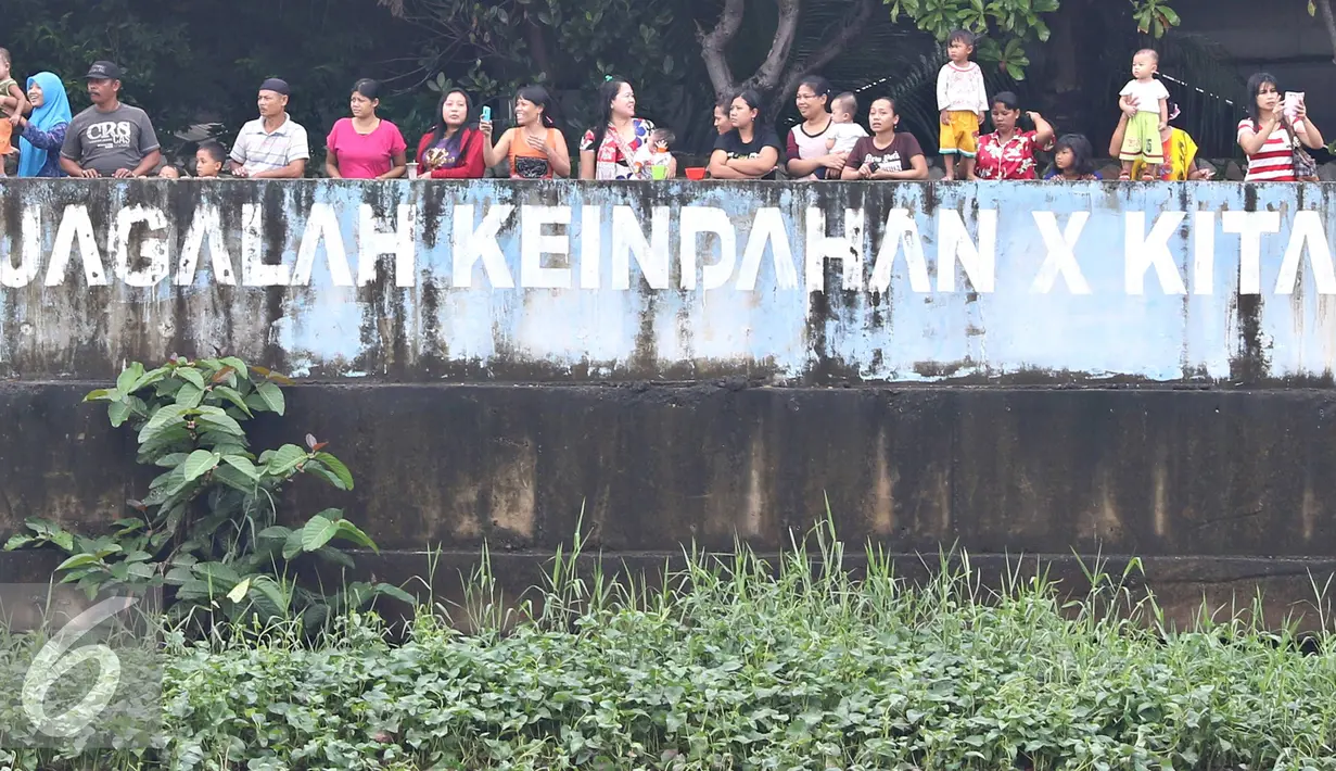 Warga menyaksikan perobohan kafe dan bangunan di kawasan prostitusi Kalijodo, Jakarta Utara, Senin (29/2). Dalam hitungan jam, puluhan bangunan di kawasan tersebut mulai rata dengan tanah serta menjadi tontonan warga. (Liputan6.com/Immanuel Antonius)