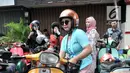 Anggota komunitas Vespa se-Jabodetabek merapikan kendaraannya saat beristirahat di sela konvoi dalam rangka memperingati Hari Kartini di Jakarta, Minggu (21/4). Dalam konvoi ini para pengendara vespa mengenakan kebaya bagi perempuan dan batik serta lurik bagi laki-laki. (merdeka.com/Iqbal Nugroho)