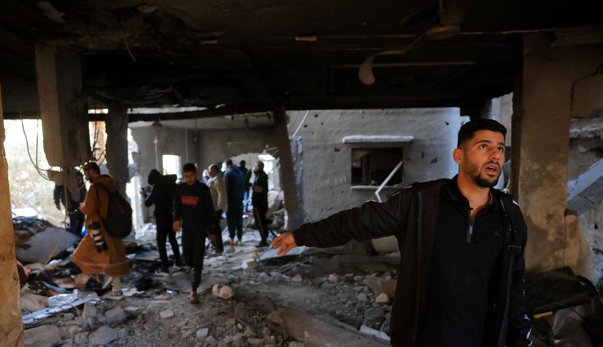 Kementerian Kesehatan Gaza dalam pernyataan tertulis pada Kamis (15/1/2026) melaporkan militer Israel masih melancarkan serangan udara di sejumlah wilayah. Tampak dalam foto, warga Palestina memeriksa rumah yang hancur setelah serangan militer Israel terhadap rumah keluarga al-Houli, di mana empat orang dilaporkan tewas, di sebelah barat Deir al-Balah, di Jalur Gaza tengah pada Jumat 16 Januari 2026. (BASHAR TALEB/AFP)