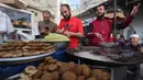 Pedagang Palestina menyiapkan falafel di pasar menjelang buka puasa selama bulan suci Ramadhan di kota Rafah, Jalur Gaza selatan, pada 10 April 2022. (SAID KHATIB / AFP)