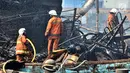 Petugas pemadam kebakaran melakukan pendinginan kapal yang ludes dilalap api di Pelabuhan Muara Baru, Jakarta, Minggu (24/2). Kebakaran diduga akibat korsleting yang dipicu oleh aktivitas pengelasan di KM Arta Minajaya. (Merdeka.com/Iqbal Nugroho)
