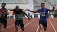 Atlet Sumatra Barat, Yaspi Boby (kanan), meraih emas lari 100m putra PON XIX Jawa Barat 2016 mengalahkan atlet NTB, Iswandi (tengah), dan atlet Jawa Tengah, Akhmad Azlan Khoirur, dalam final di Stadion Pakansari, Bogor, Kamis (22/9/2016). (Bola.com/Arief 