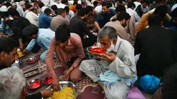 Umat Islam Pakistan berbuka puasa bersama di sepanjang jalan di Rawalpindi pada 7 Mei 2019. Ketika bulan suci Ramadan mulai di Pakistan, banyak masyarakat muslim memanfaatkan buka puasa gratis yang disponsori oleh badan-badan amal dan orang-orang kaya. (RIZWAN TABASSUM / AFP)