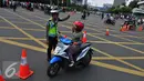 Petugas memberi petunjuk kepada pengendara motor saat pengalihan arus di kawasan Sarinah, Jakarta, Jumat (4/11). Pengalihan arus lalu lintas ini disebabkan karena beberapa titik jalan tidak bisa digunakan akibat aksi massa. (Liputan6.com/Angga Yuniar)
