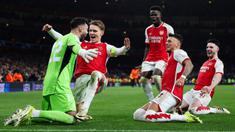 Pemain Arsenal merayakan kemenangan setelah David Raya berhasil menepis dua tendangan penalti dari pemain Porto pada laga leg kedua 16 besar Liga Champions 2023/2024 di Emirates Stadium, London, Inggris, Rabu (13/03/2024). (AFP/Adrian Dennis)