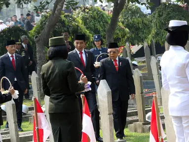 Presiden Joko Widodo bersama Wakil Presiden Ma'ruf Amin bersiap melakukan tabur bunga usai upacara peringatan Hari Pahlawan Nasional di Taman Makam Pahlawan (TMP) Utama Kalibata, Jakarta Selatan, Minggu (10/11/2019). (Liputan6.com/Herman Zakharia)