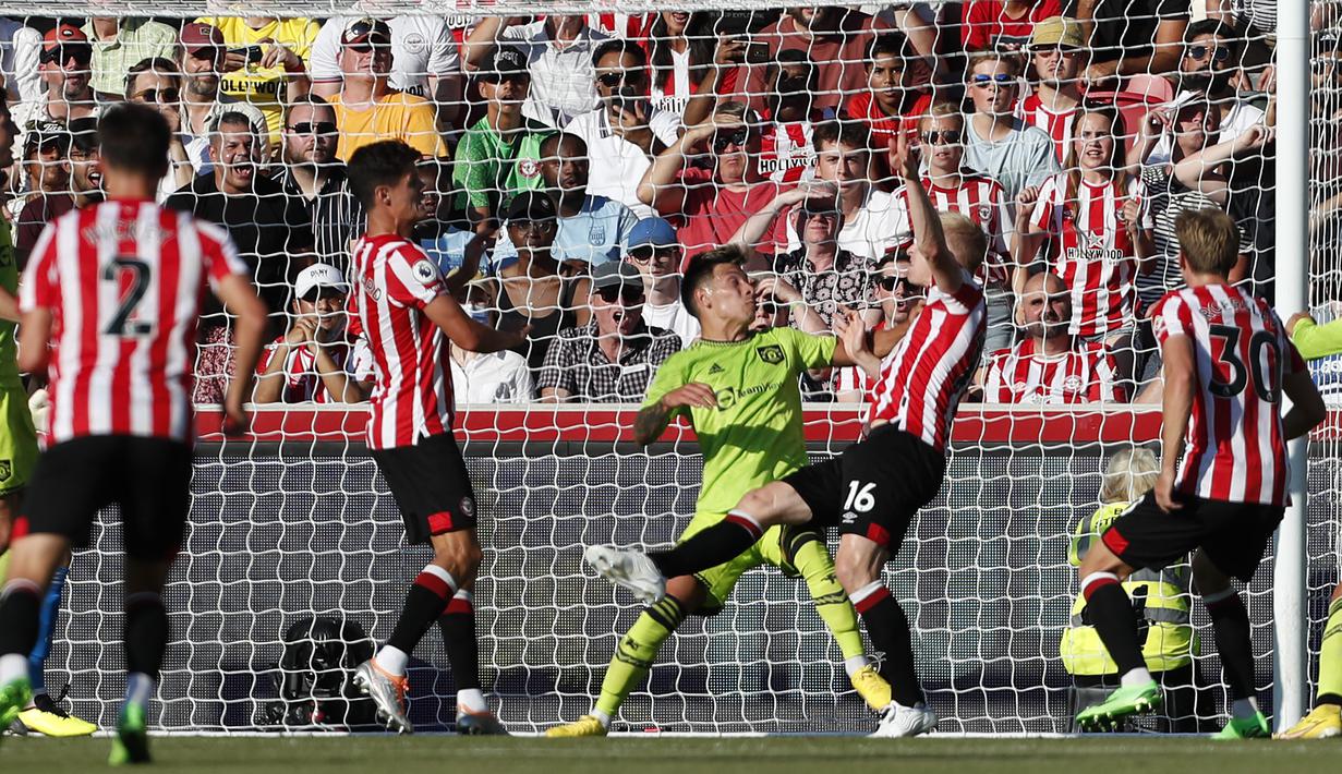 Bek Brentford, Ben Mee (kedua kiri) saat mencetak gol ke gawang Manchester United pada pertandingan lanjutan Liga Inggris di Gtech Community Stadium di London, Sabtu (13/8/2022). Brentford menang telak atas MU 4-0. (AFP Photo / Ian Kington)