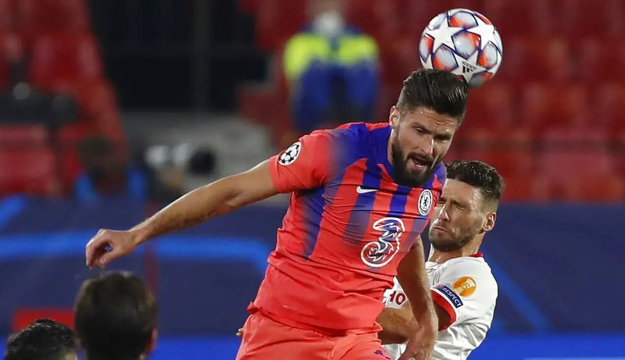 Striker Chelsea, Olivier Giroud, menyundul bola saat melawan Sevilla pada laga Liga Champions di Stadion Ramon Sanchez Pijuan, Kamis (3/12/2020). Chelsea Menang dengan skor 4-0. (AP/Angel Fernandez)