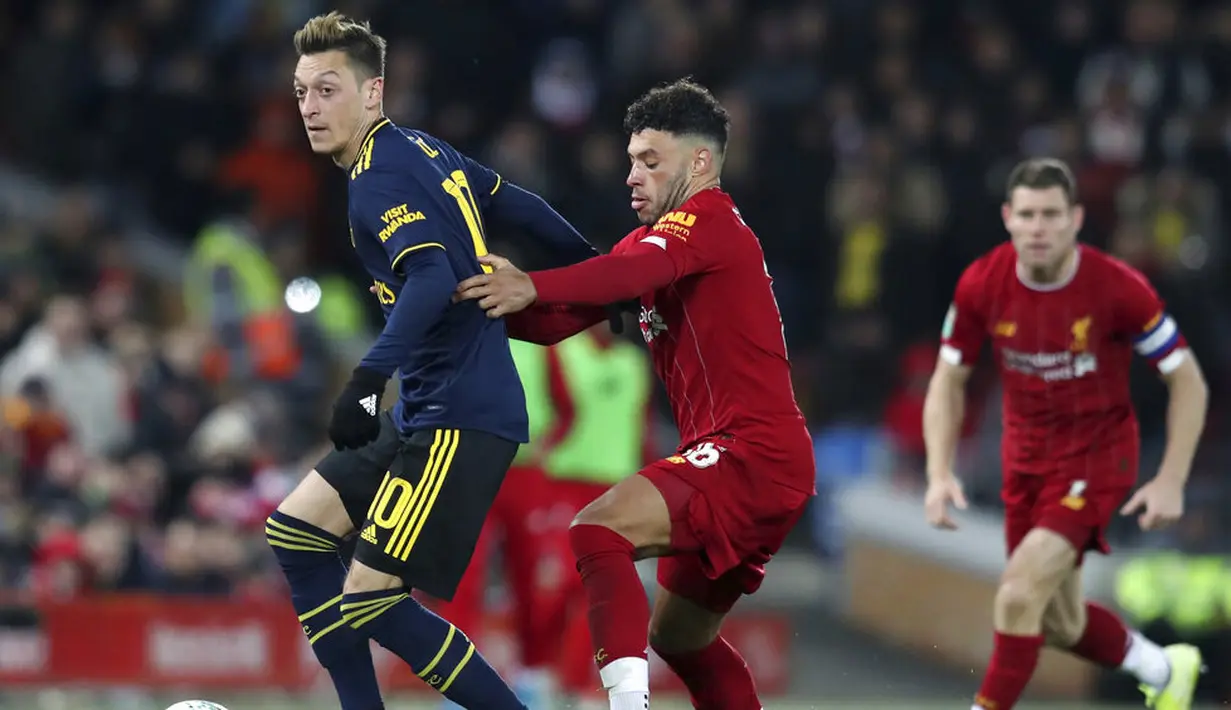 Gelandang Liverpool, Alex Oxlade-Chamberlain, berebut bola dengan gelandang Arsenal, Mesut Ozil, pada laga Piala Liga Inggris 2019 di Stadion Anfield, Rabu (30/10). Liverpool menang adu penalti atas Arsenal dengan skor 5-4. (AP/Jon Super)