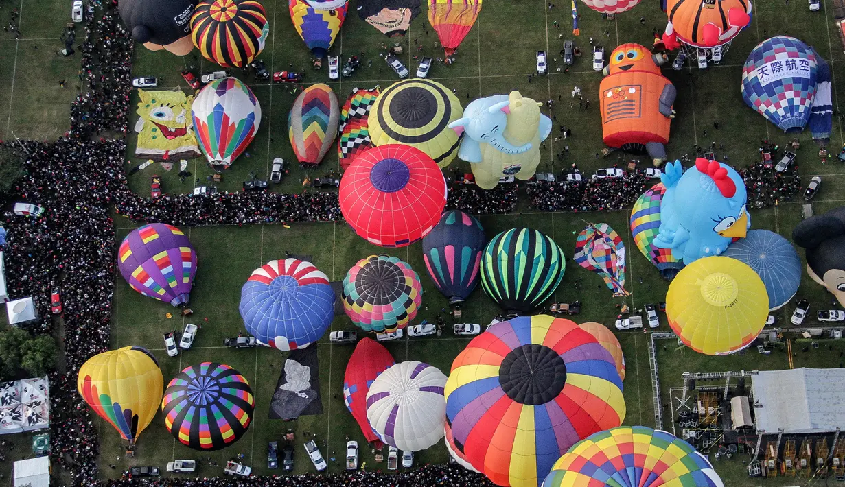 Sejumlah peserta mengikuti Festival Balon Udara Internasional XVIII di Taman Metropolitan, Leon, negara bagian Guanajuato, Meksiko pada 16 November 2019. Tak hanya balon udara biasa, banyak yang memiliki bentuk, serta warna unik menyemarakkan langit Kota Leon. (MARIO ARMAS / AFP)