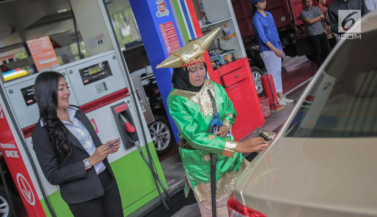 Petugas SPBU mengenakan pakaian adat mengisi bahan bakar minyak (BBM) ke sebuah mobil di kawasan Kelapa Gading, Jakarta, Senin (22/4). Dalam rangka memperingati Hari Kartini pengelola SPBU mengajak Seluruh pegawai SPBU mengenakan mengenakan baju kebaya dan baju adat. (Liputan6.com/Faizal Fanani)
