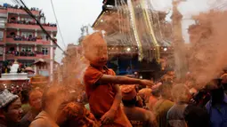 Seorang anak menaburkan bubuk vermillion saat perayaan sindoor Jatra festival di Bhaktapur, Nepal (15/4). Perayaan ini untuk menyambut datangnya musim semi dan Tahun Baru. (AP Photo/Niranjan Shrestha)