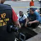 Aparat Kepolisian Polda Metro Jaya melakukan olah TKP di gorong-gorong Jalan Medan Merdeka Selatan, Jakarta, Sabtu (5/3/2016). Di gorong-gorong tersebut petugas menemukan sisa kulit kabel yang diduga menjadi penyebab banjir. (Liputan6.com/Johan Tallo)