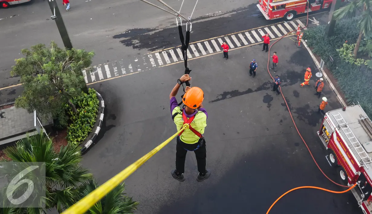 Korban kebakaran diselamatkan menggunakan teknik flying fox saat simulasi penanggulangan kebakaran di Senayan City, Jakarta, Kamis (2/6). Kegiatan ini dilakukan setiap tahunnya yang diikuti seluruh karyawan pusat perbelanjaan. (Liputan6.com/Fery Pradolo)