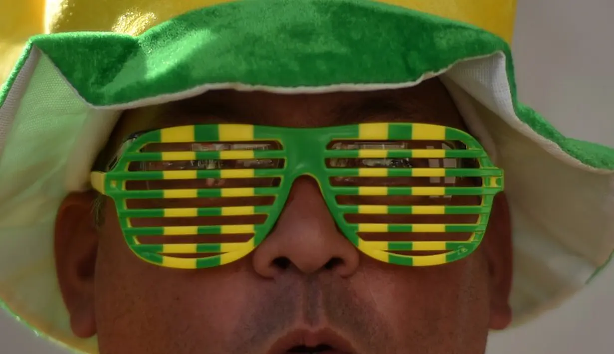 Seorang suporter Brasil memakai kacamata unik saat akan menonton laga pembuka Brasil vs Kroasia, Sao Paulo, Brasil, Kamis (12/6/2014) (AFP PHOTO/KIRILL KUDRYAVTSEV)