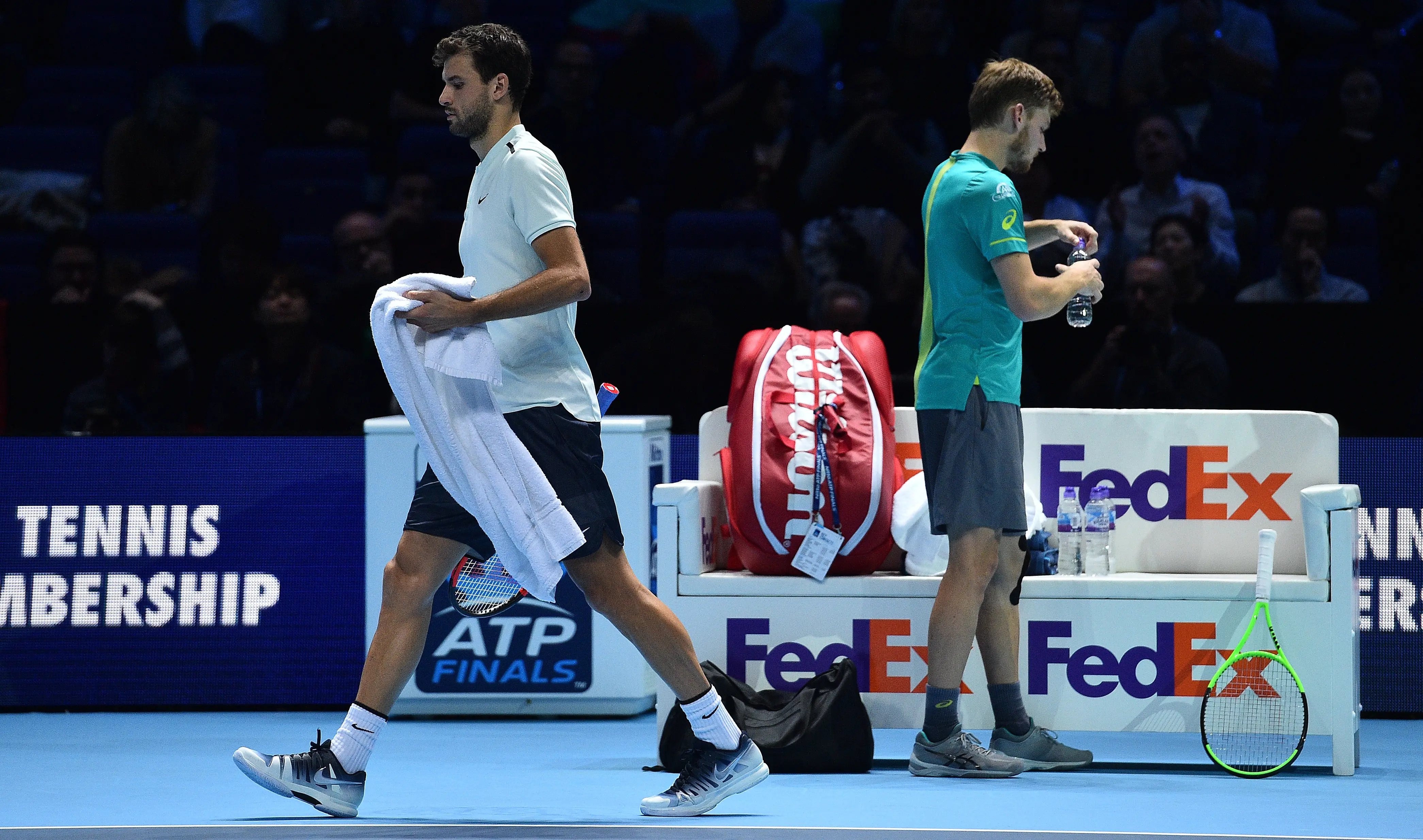 Grigor Dimitrov (kiri) melewati David Goffin pada laga puncak ATP World Tour Finals. (AFP/Glyn Kirk)