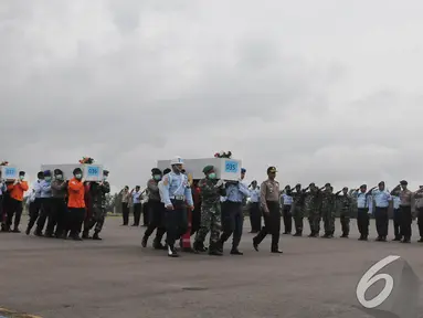 Petugas membawa peti berisi jenazah penumpang AirAsia QZ8501, Pangkalan Bun, Kalteng, Senin (5/1/2015). (Liputan6.com/Herman Zakharia)