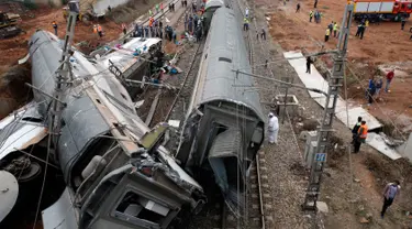 Orang-orang berkumpul setelah sebuah kereta api keluar jalur dan terguling di Sidi Bouknadel dekat ibu kota Rabat, Maroko, Selasa (16/10). Akibat insiden ini, 6 penumpang tewas dan puluhan lainnya mengalami luka-luka. (AP/Abdeljalil Bounhar)