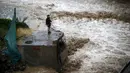 Seorang pria terlihat di sebelah sungai saat banjir melanda Ibu Kota Chile, Santiago, Minggu (17/4). Hujan lebat dan parah di Ibu Kota Chile selama akhir pekan lalu menyebabkan 1 orang tewas dan 7 orang masih dinyatakan hilang. (REUTERS/Ivan Alvarado)