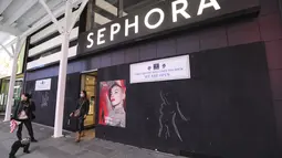 Pejalan kaki terlihat di depan sebuah toko yang dipasangi papan pelindung di Times Square di New York, Amerika Serikat pada 1 November 2020. Langkah itu dilakukan saat para peretail berupaya melindungi properti dari penjarahan atau kerusuhan lainnya dalam beberapa hari mendatang (Xinhua/Wang Ying)