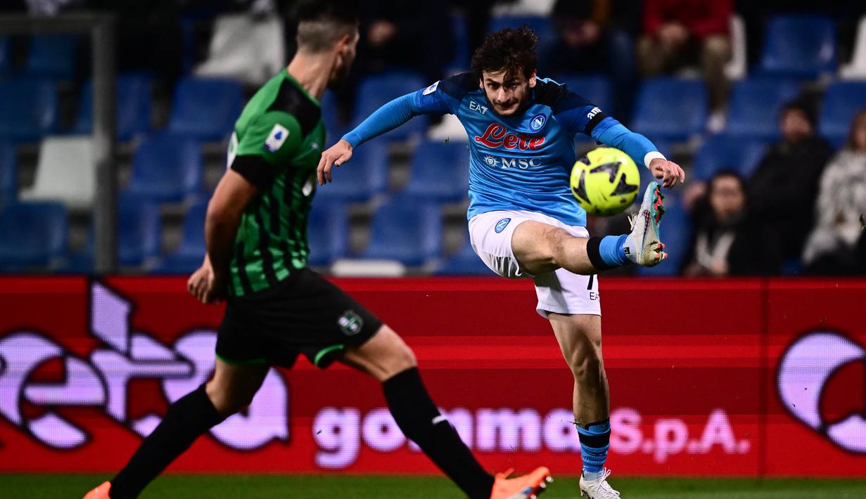 Pemain Napoli, Khvicha Kvaratskhelia (kanan) menendang bola ke gawang Sassuolo dalam pertandingan pekan ke-23 Liga Italia 2022/2023 yang berlangsung di Mapei Stadium, Sabtu (18/2/2023). Gol Kvaratskhelia ke gawang Sassuolo membuat dirinya masuk lima besar pencetak gol terbanyak sementara Serie A musim ini dengan 10 gol. (AFP/Marco Bertorello)