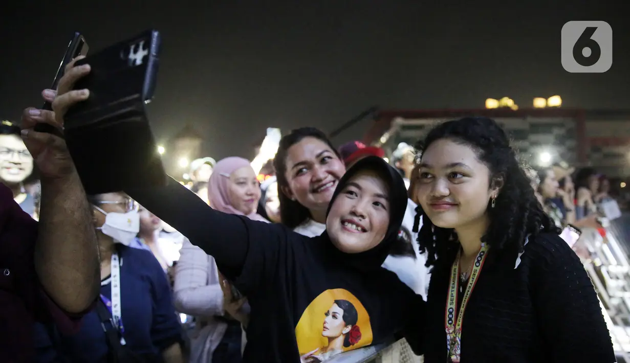 Amora Lemos berfoto dengan penonton saat hadir untuk menyaksikan KD tampil di Synchronize Fest 2023. (Kapanlagi.com/Bambang Ekoros Purnama)