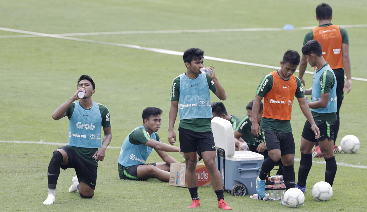 Pemain Timnas Indonesia U-22 melepas dahaga saat latihan di Stadion Madya, Jakarta, Selasa (15/1). Latihan ini merupakan persiapan jelang Piala AFF U-22. (Bola.com/Yoppy Renato)