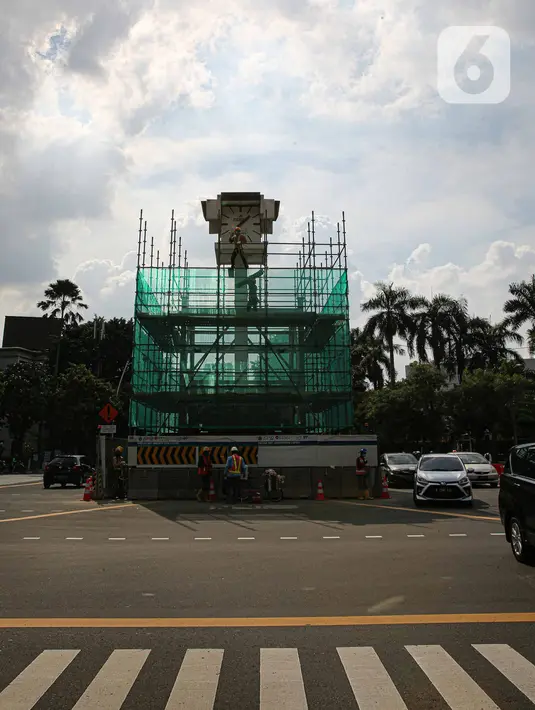Pekerja memasang penutup di Tugu Jam Thamrin, Jakarta, Kamis (18/11/2021). PT MRT Jakarta (Perseroda) dalam waktu dekat akan memindahkan sementara Tugu Jam Thamrin di Jakarta Pusat yang merupakan bangunan cagar budaya. (Liputan6.com/Faizal Fanani)