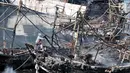 Seorang pria melakukan pendinginan kapal yang ludes dilalap api di Pelabuhan Muara Baru, Jakarta, Minggu (24/2). Belum diketahui mengenai taksiran kerugian materil akibat kebakaran tersebut. (Merdeka.com/Iqbal Nugroho)