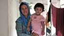 Seorang imigran pencari suaka menggendong anak di penampungan sementara di Kalideres, Jakarta, Rabu (18/12/2019). Untuk listrik, para imigran di tempat ini secara swadaya atau patungan membayar tagihan. (merdeka.com/Iqbal Nugroho)