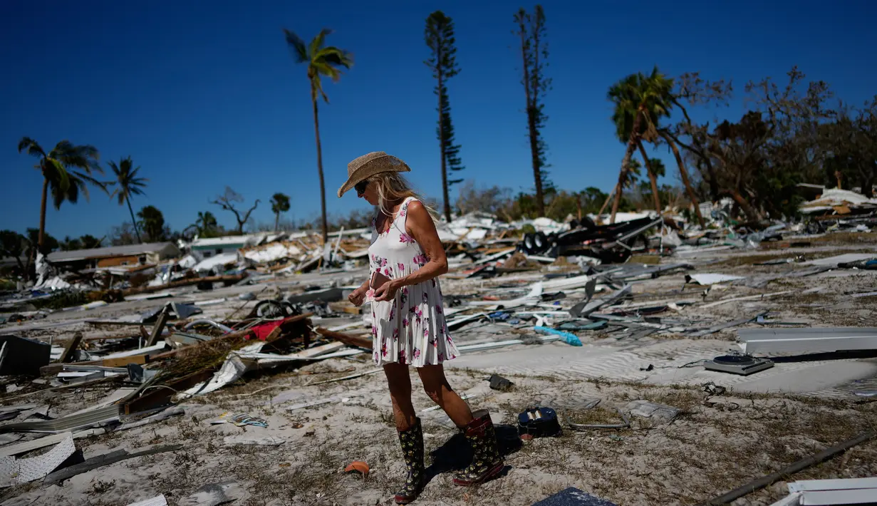Holly Ciaglia mencari barang-barang pribadinya dan rekannya Evan Mackay dua hari setelah Badai Ian di Red Coconut RV Park, Pantai Fort Myers, Florida, Amerika Serikat, 30 September 2022. Di Fort Myers, rumah-rumah hancur dan tertimbun di antara puing-puing reruntuhan yang hancur. (AP Photo/Rebecca Blackwell)
