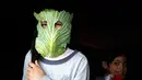 Seorang anak berpose dengan masker dari kubis di tengah wabah pandemi corona (Covid-19) di Beit Lahia di Jalur Gaza utara (16/4/2020). Di tengah pandemi Covid-19, seorang ibu di Jalur Gaza utara mencoba menghibur anak-anaknya dengan masker yang dibuat dari sayuran kubis. (AFP/Mohamed Abed)