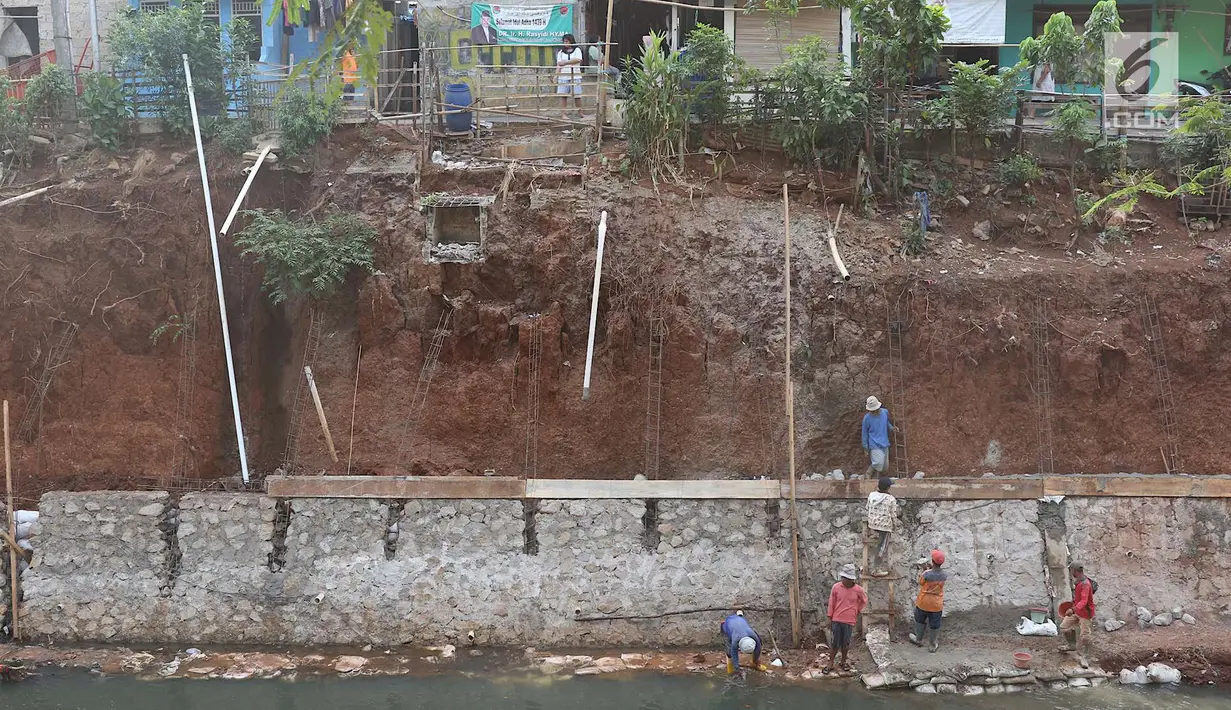 Pekerja membangun turap di bantaran Kali Cijantung, Jakarta Timur, Kamis (11/10). Pembangunan turap bertujuan mencegah longsor yang dapat membahayakan warga sekitar. (Liputan6.com/Immanuel Antonius)