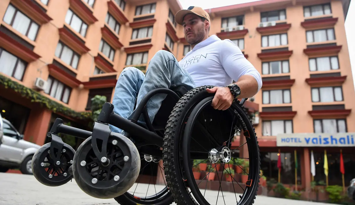 Pria asal Australia, Scott Doolan beraktivitas dengan kursi rodanya di Kathmandu, Nepal, Kamis (15/3). Scott Doolan ingin menjadi orang lumpuh pertama yang bisa mencapai Everest. (AFP Photo/Prakash Mathema)