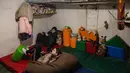 Anak-anak menonton televisi di ruang bawah tanah di bawah pemadaman listrik di kota Bakhmut, Ukraina timur (22/12/2022). Mereka mencari perlindungan karena penembakan hebat oleh pasukan Rusia. (AFP/Sameer Al-Doumy)
