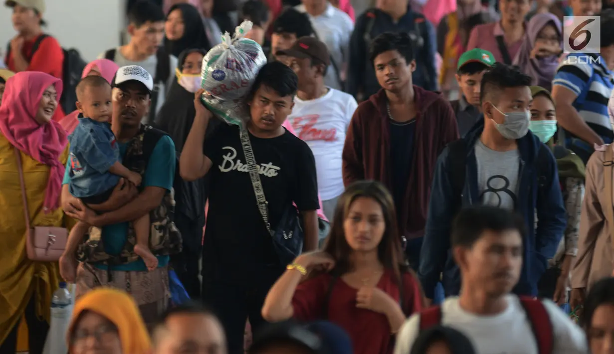Pemudik berjalan menuju pintu kedatangan di Stasiun Pasar Senen, Jakarta, Sabtu (8/6/2019). Volume penumpang arus balik melalui moda transportasi kereta api  di stasiun Stasiun Senen mengalami lonjakan pada H+3 Lebaran. (merdeka.com/Imam Buhori)
