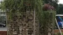 Petugas merapikan tanaman di dekat instalasi batu gabion yang kembali dipasang di kawasan Bundaran HI, Jakarta, Sabtu (4/1/2020). Instalasi gabion di lokasi yang sama tersebut sempat dibongkar sementara untuk dijadikan panggung saat perayaan malam tahun baru. (Liputan6.com/Herman Zakharia)