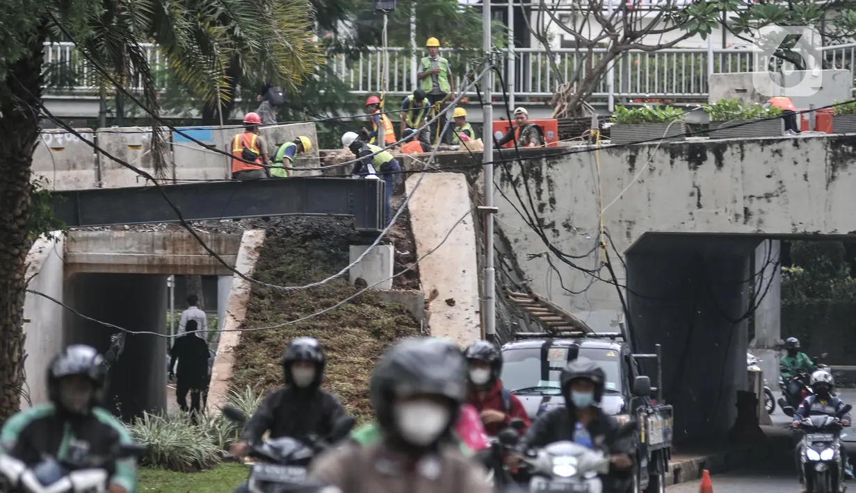 Aktivitas pekerja saat menyelesaikan pembangunan proyek jalur sepeda di Terowongan Semanggi, Jakarta, Kamis (6/10/2022). Diketahui, Pemerintah Provinsi DKI Jakarta berencana membangun jalur sepeda sepanjang 196,45 kilometer pada 26 ruas jalan di wilayah Ibu Kota, terdiri atas 40,06 kilometer jalur sepeda terproteksi, 154,73 kilometer jalur sepeda berbagi, dan 1,67 jalur sepeda di trotoar. (merdeka.com/Iqbal S. Nugroho)