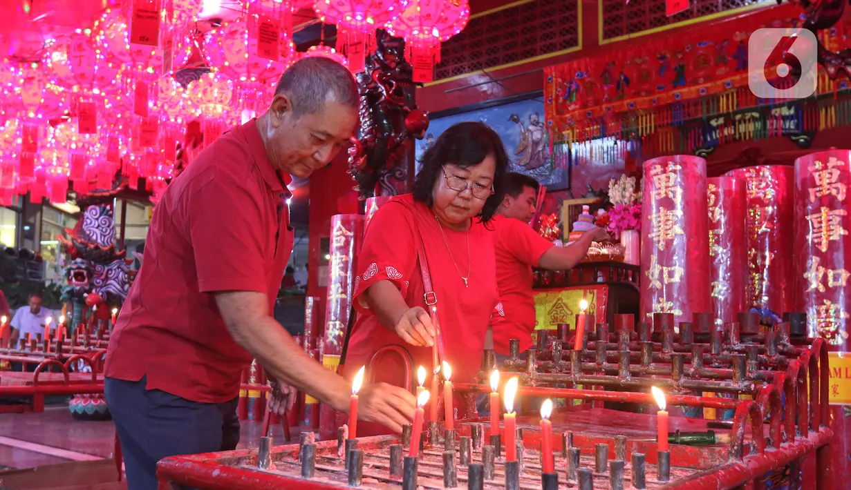 Warga keturunan Tionghoa menyalakan lilin saat sembahyang Vihara Amurva Bhumi, kawasan Karet Semanggi, Jakarta, Jumat (24/1/2020) malam. Ibadah tersebut dalam rangka menyambut Tahun Baru Imlek 2571/2020. (Liputan6.com/Herman Zakharia)