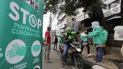 Ojek online (ojol) menerima bantuan berupa bingkisan makan siang dan hand sanitizer di kawasan Jalan Raden Saleh, Jakarta, Selasa (7/3/2020). DPP PKB memberikan 500 paket kepada ojol akibat lesunya orderan selama pandemi corona Covid-19. (Liputan6.com/Fery Pradolo)
