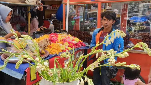 Asep Kembang, salah satu penjual bunga rampes di Kawasan Pengkolan, Jalan A. Yani Garut, Jawa Barat tengah sibuk melayani pembeli.