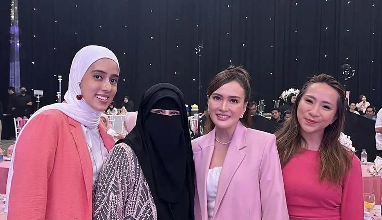 Shandy Aulia mengenakan blazer pink dipadukan inner dress putih sambil membawa pouch coklat. [@_ummi_pipik_]