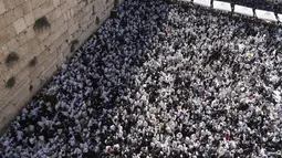 Pria-pria Yahudi berdoa dengan mengenakan selendang saat mereka berpartisipasi dalam pemberkatan selama hari raya Yahudi Sukkot di Tembok Barat di bawah masjid Kubah Batu di Kota Tua Yerusalem, Rabu, 12 Oktober 2022. (AP Photo/Tsafrir Abayov)